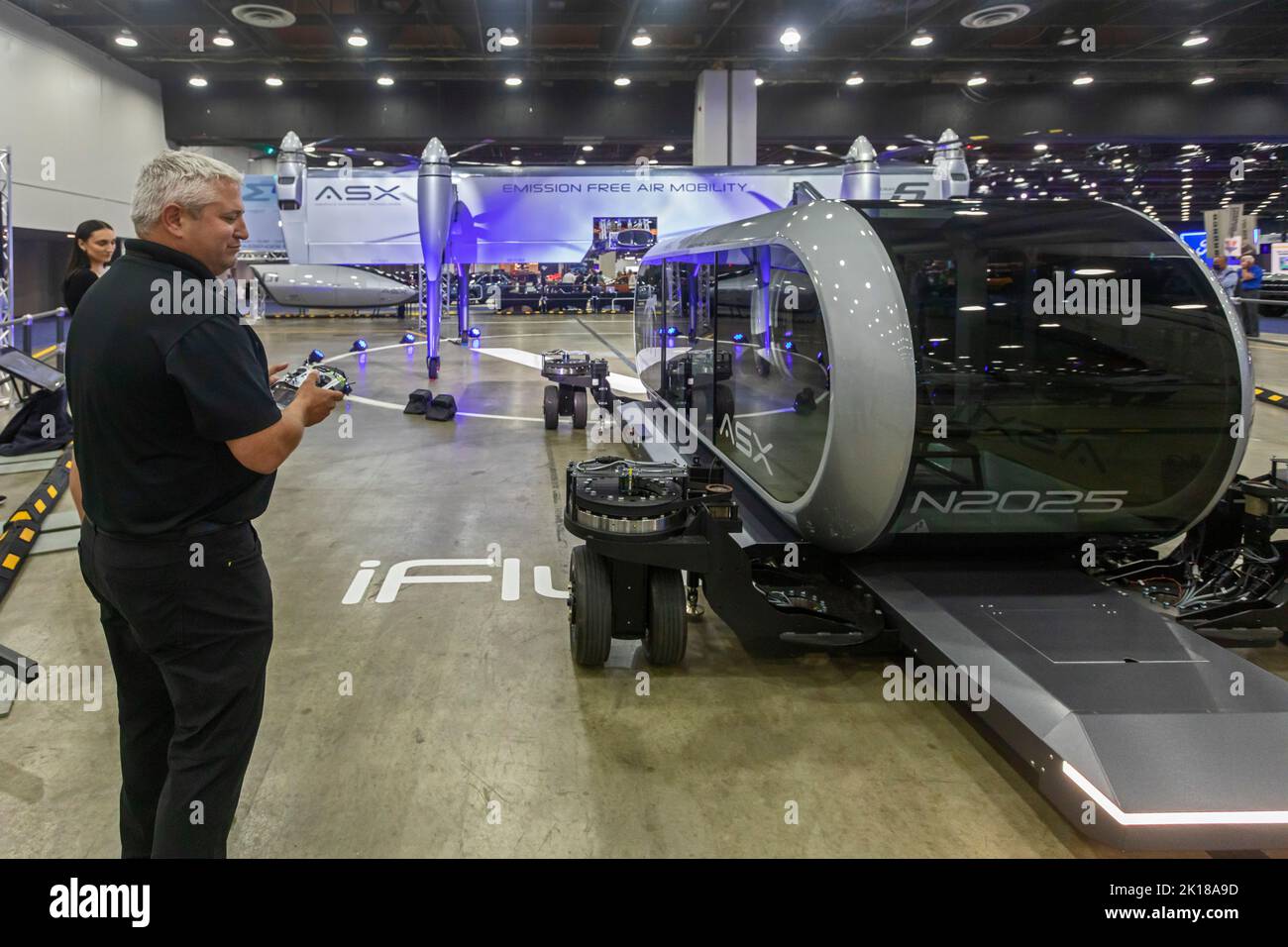 Detroit, Michigan, USA. 15th Sep, 2022. Airspace Experience Technologies displayed an electric vertical take off and landing aircraft at the North American International Auto Show. A worker guides a cargo modulr towards the aircraft. Cargo containers can be switched in a few minutes or replaced with a module carrying passengers. Credit: Jim West/Alamy Live News Stock Photo