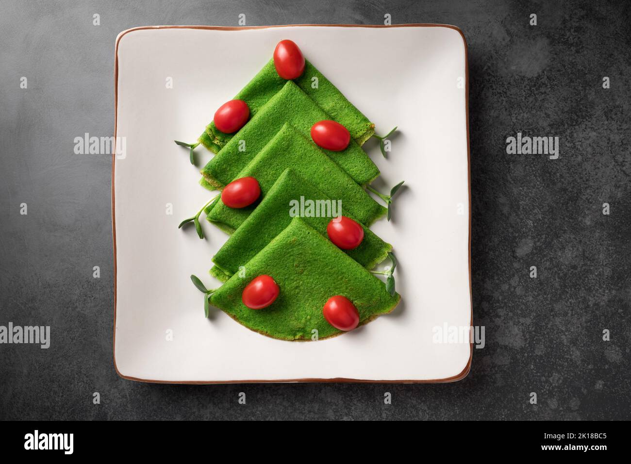 Christmas tree made of green spinach thin pancakes Stock Photo