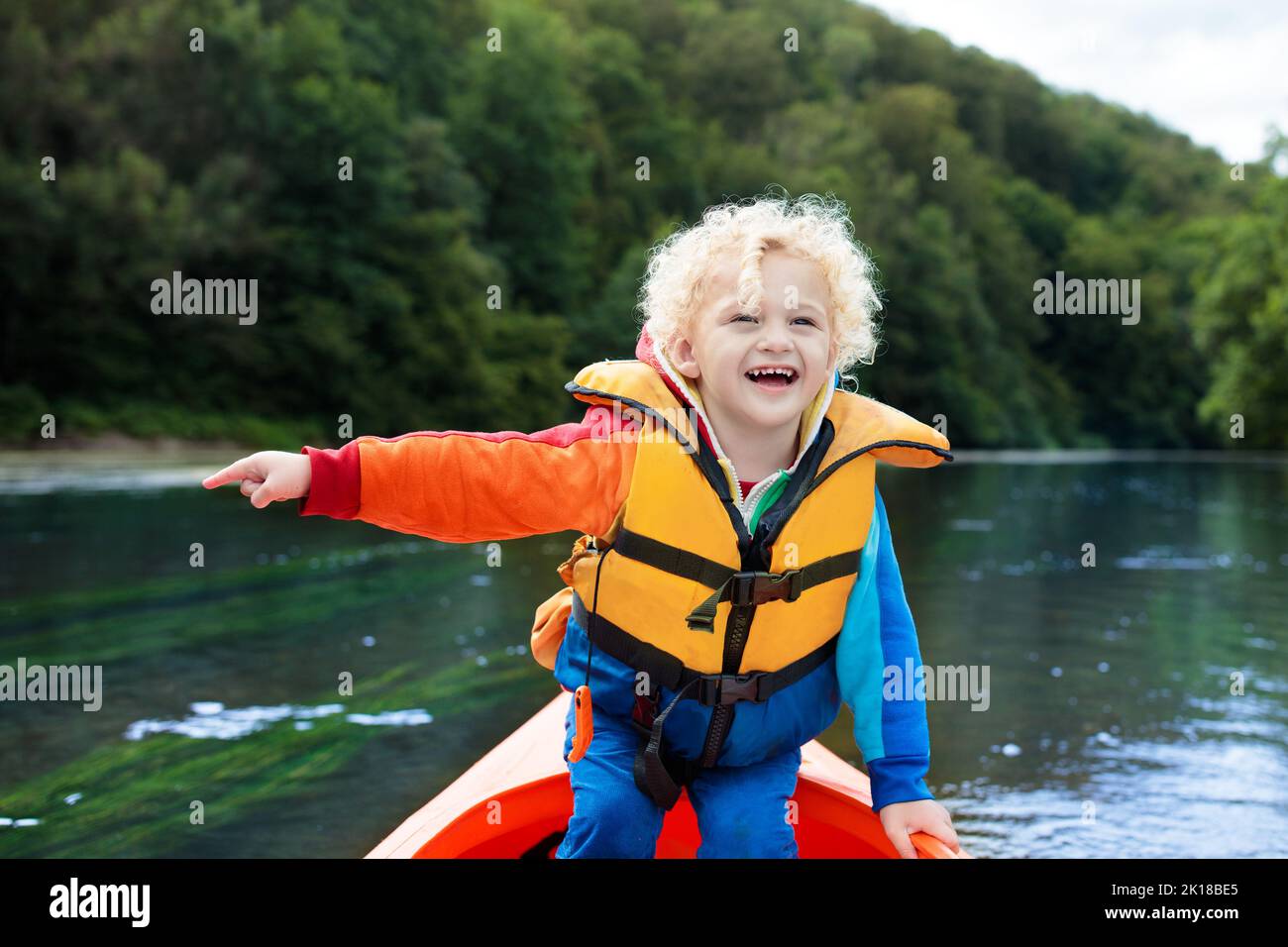 Child with paddle on kayak. Summer camp for kids. Kayaking and canoeing with family. Children on canoe. Little boy on kayak ride. Wild nature and wate Stock Photo