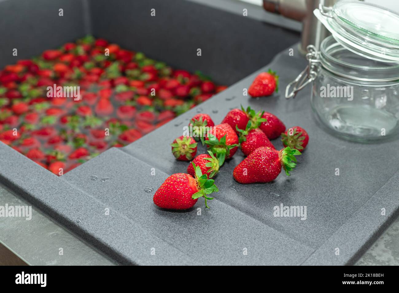 heap of ripe strawberries on kitchen counter top. process of making strawberry jam or dessert Stock Photo