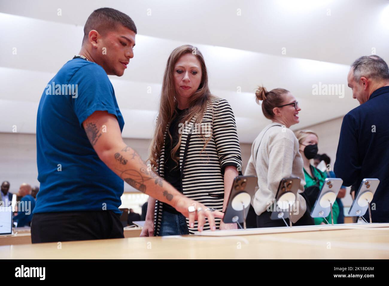Chelsea Clinton is shown the Apple iPhone 14 range by a worker at the Apple Fifth Avenue store in Manhattan, New York City, U.S., September 16, 2022.  REUTERS/Andrew Kelly Stock Photo