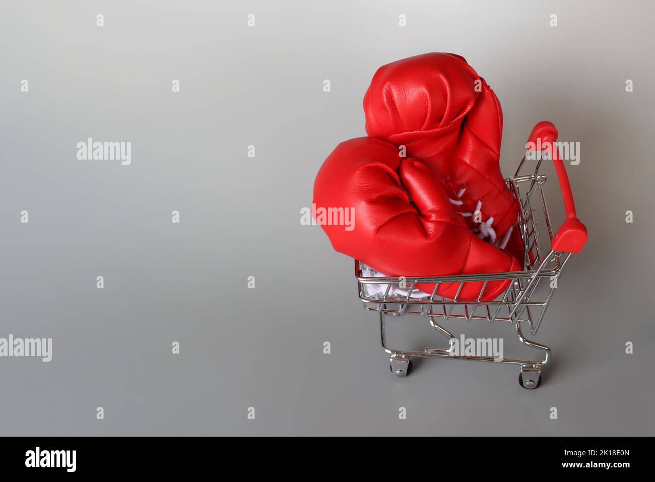 Boxing gloves inside shopping trolley with copy space. Fight inflation concept Stock Photo