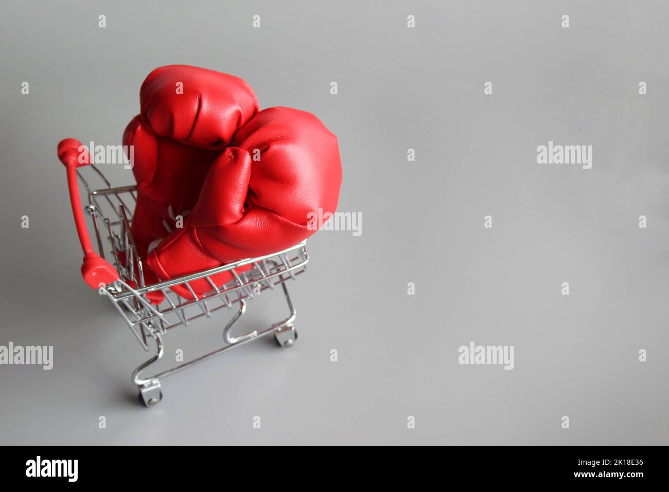 Boxing gloves inside shopping trolley with copy space. Fight inflation concept Stock Photo