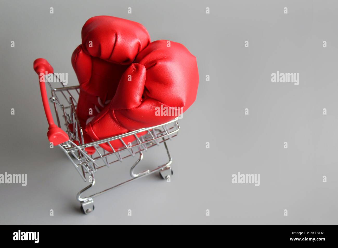 Boxing gloves inside shopping trolley with copy space. Fight inflation concept Stock Photo