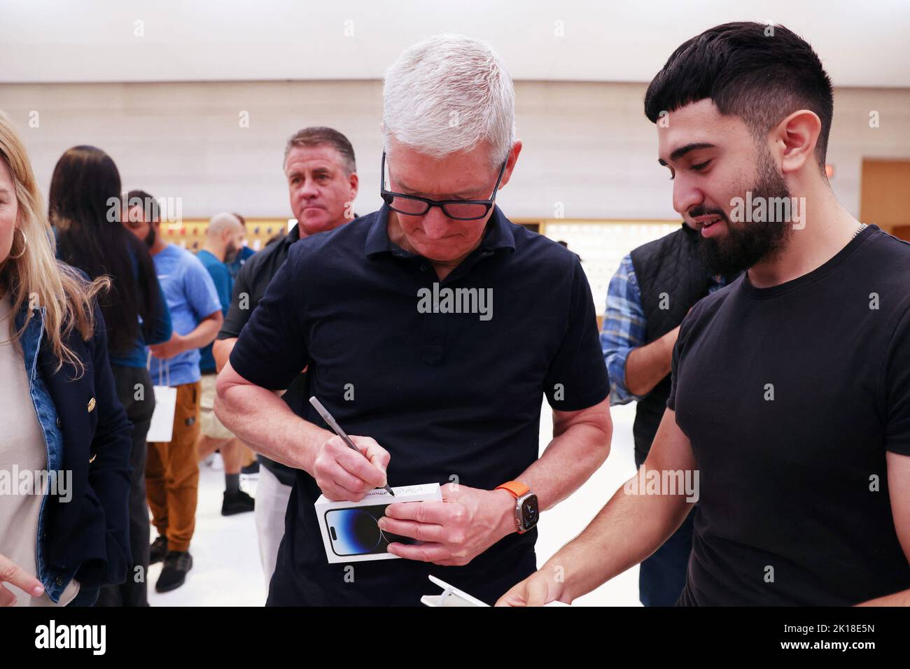 Apple CEO Tim Cook signs the box of a new iPhone at the Apple Fifth Avenue store for the release of the Apple iPhone 14 range in Manhattan, New York City, U.S., September 16, 2022.  REUTERS/Andrew Kelly Stock Photo