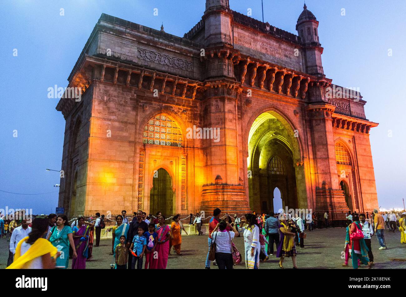 Mumbai, Maharashtra, India : People gather at dusk around the illuminated Gateway of India monumental arch built betwen 1913 and 1924 in the Indo-Sara Stock Photo