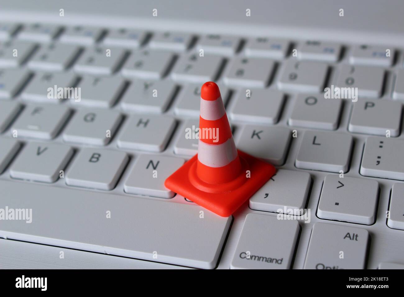 Computer system under construction, maintenance, repair concept. Safety cone and keyboard computer Stock Photo