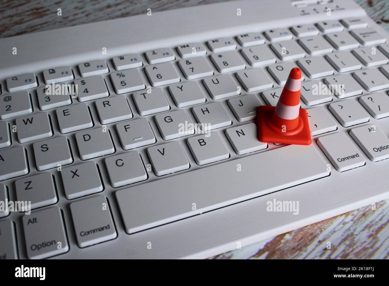Computer system under construction, maintenance, repair concept. Safety cone and keyboard computer Stock Photo