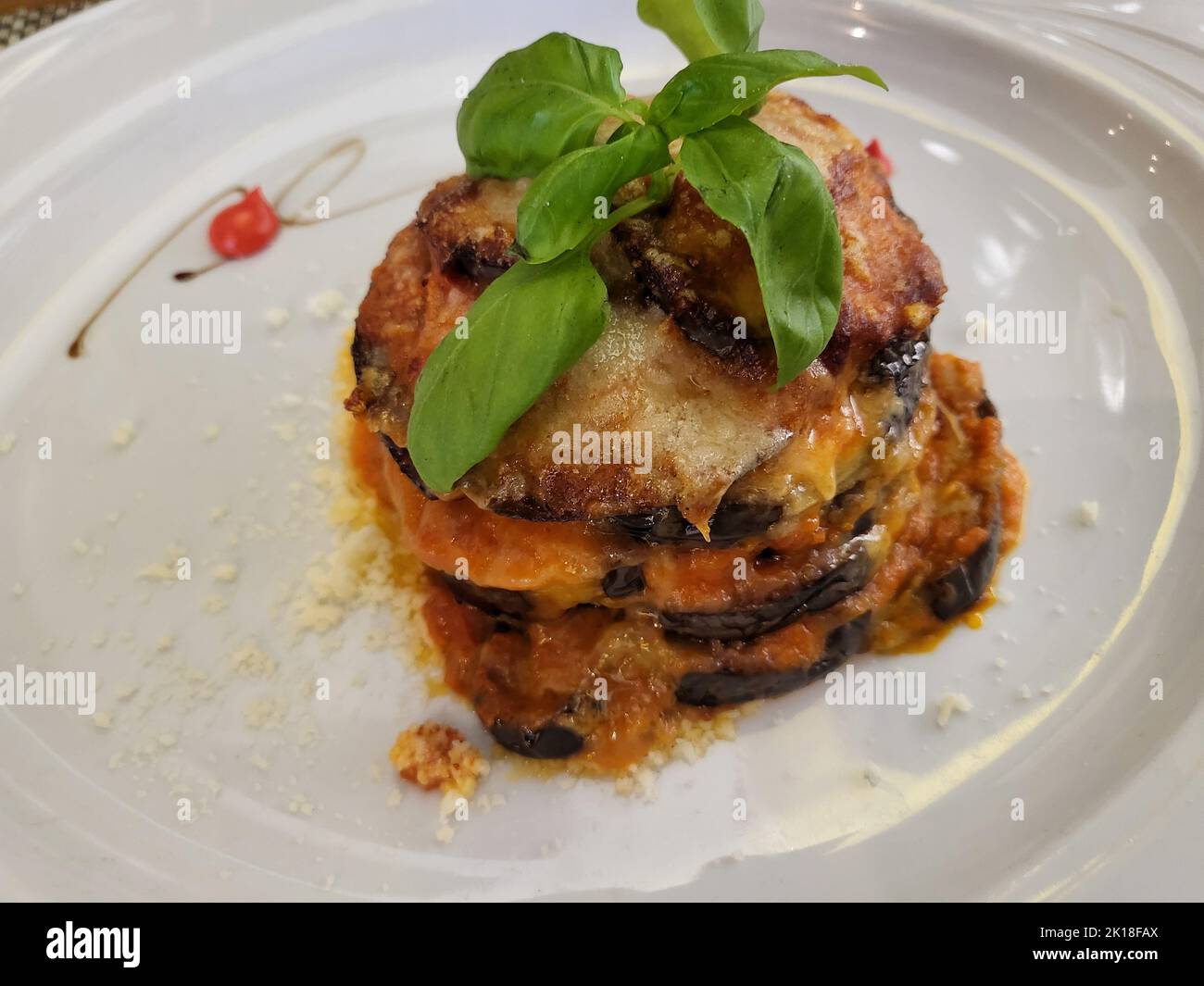 Eggplant parmigiana tower with herb oil, moussaka or eggplant casserole