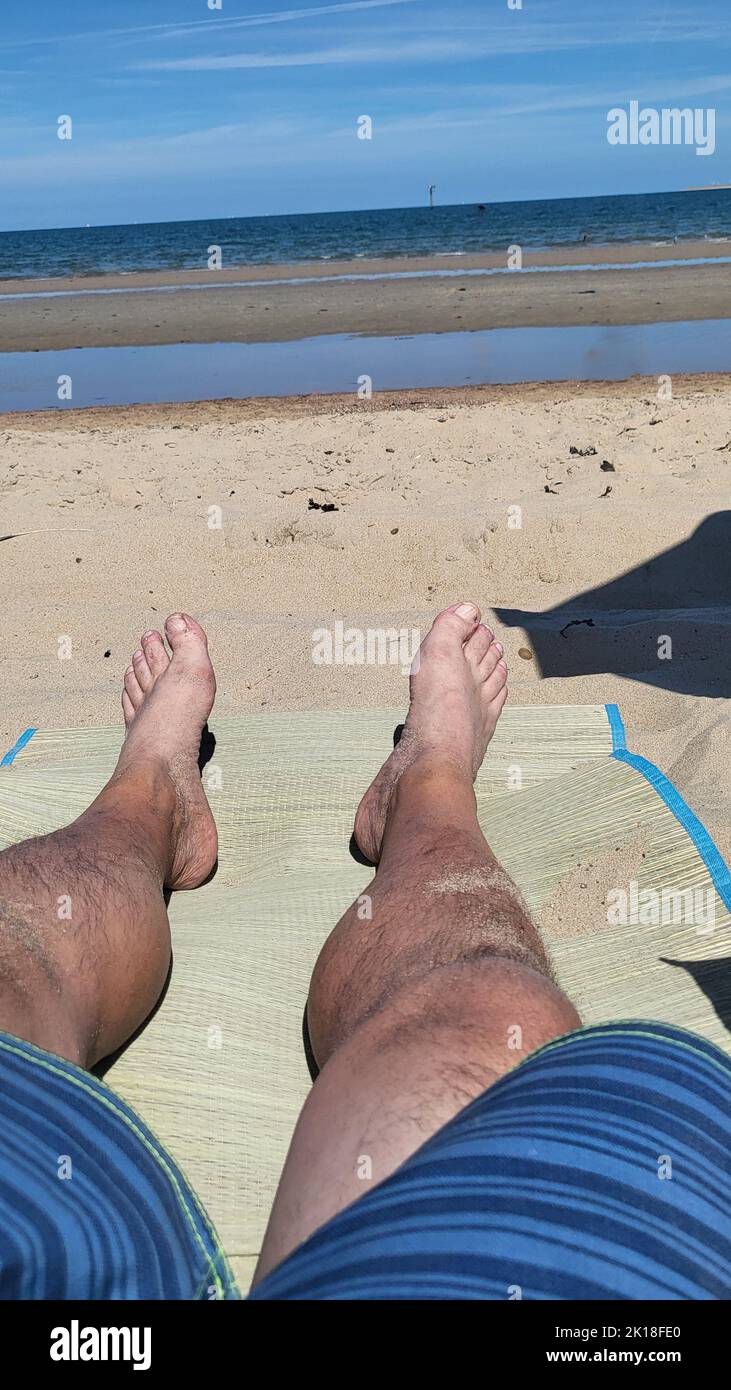 Vacation photo of a couple of feet relaxing on the beach Stock Photo