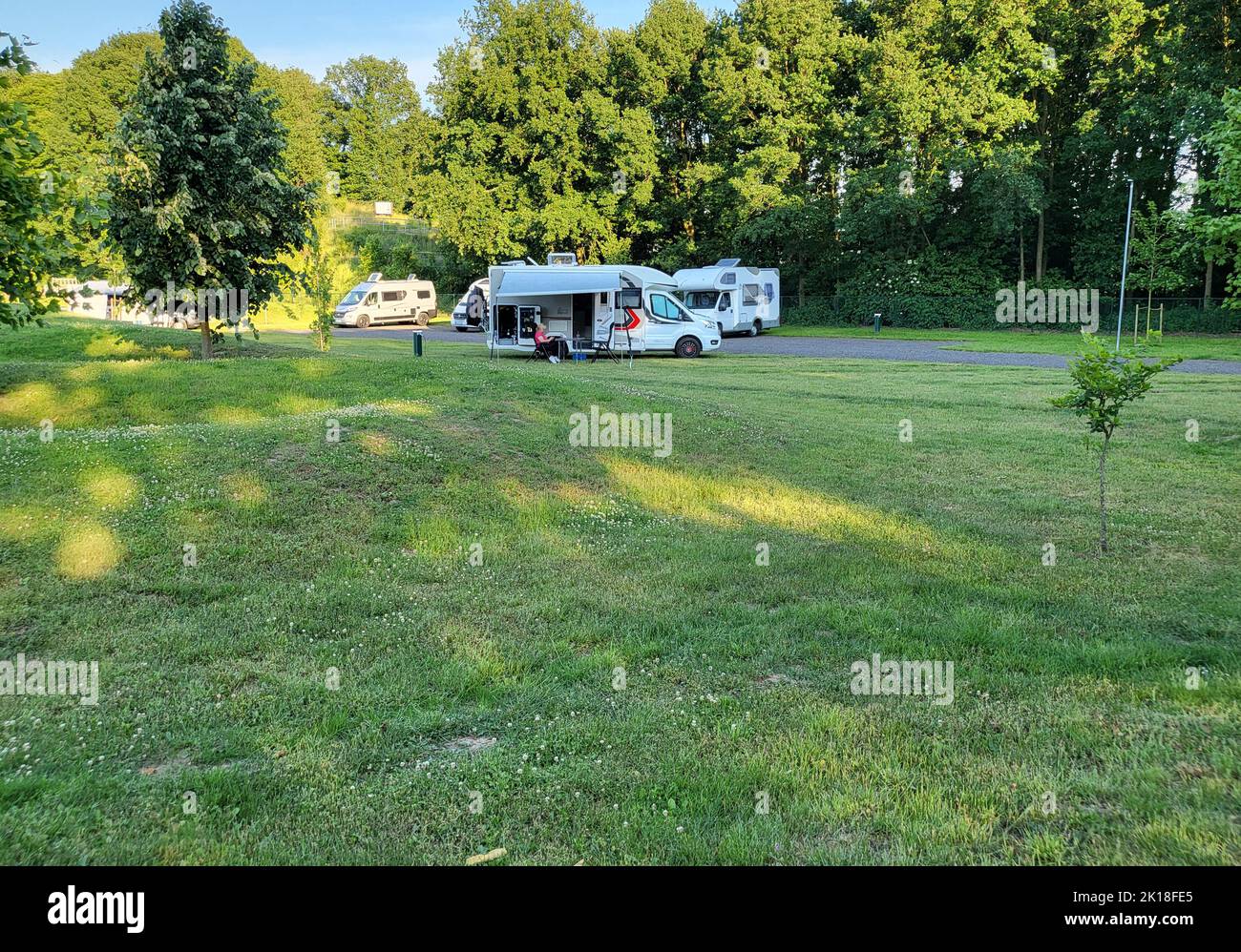 Mobile home with awning and awning and camping table with chairs on the campsite Stock Photo