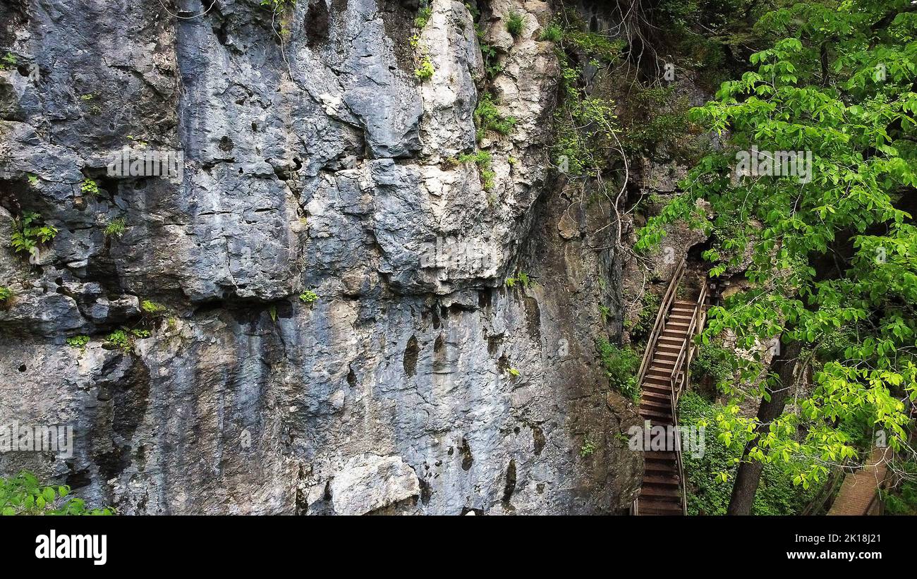 May 30, 2020, MAQUOKETA, IOWA, USA: Wooden stairs hug the cliff coming out of ''Middle Dancehall Cave'' in Maquoketa Caves State Park located at 9688 Caves Rd., Maquoketa, Iowa..About 13 caves can be found in the park, some of which can be explored by walking, while others are better suited for serious spelunkers who are used to crawling in tight spaces..With more caves than any state park, Maquoketa Caves is one of Iowaâ€™s most popular outdoor attractions. .Enormous bluffs tower throughout the park, and a six-mile trail system winds through geologic formations and forests brimming with natur Stock Photo