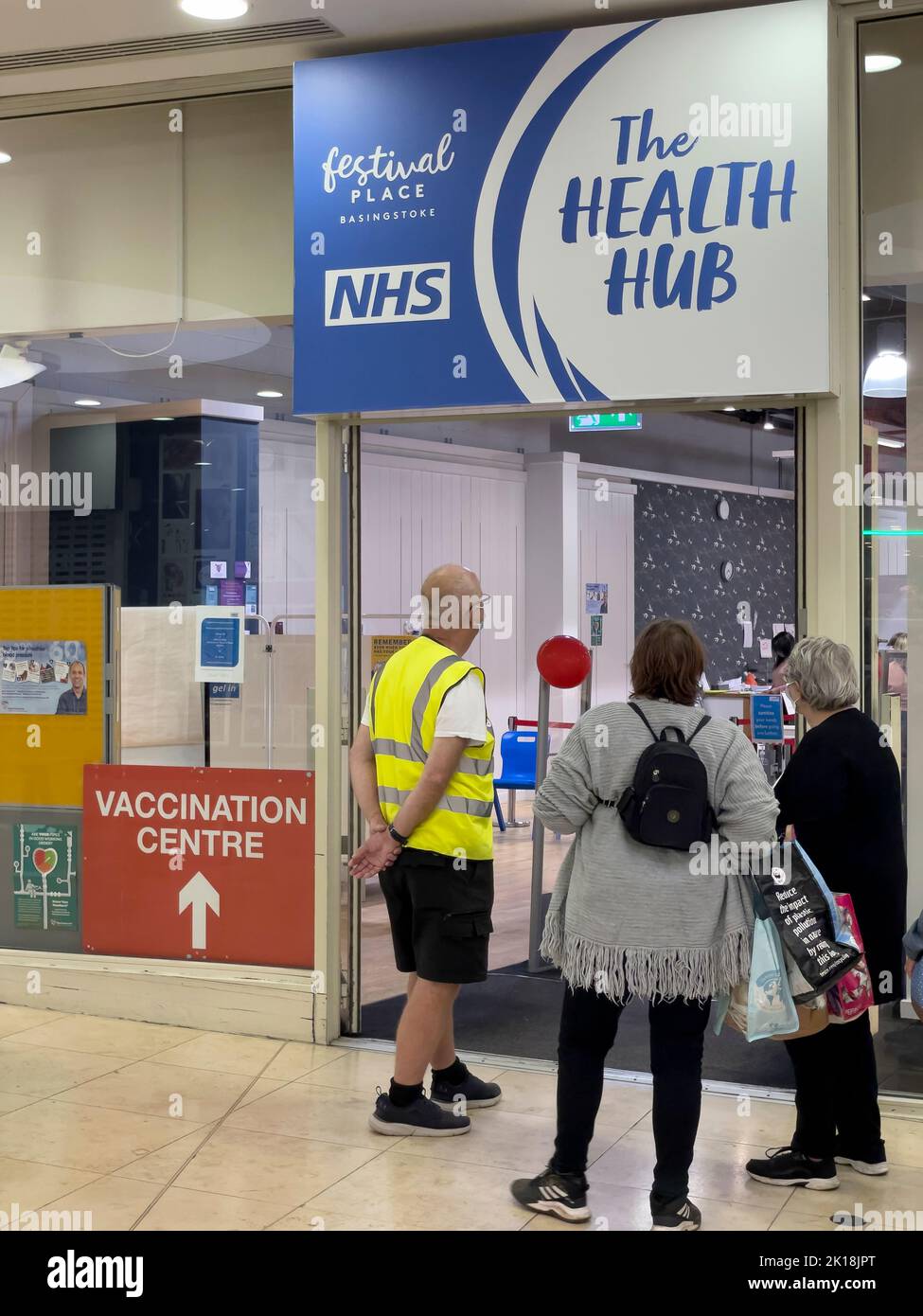 Basingstoke, Hampshire, England, UK. 2022. Elderly people standing in line at the NHS Health Hub waiting to receive an autumn booster vaccination for Stock Photo