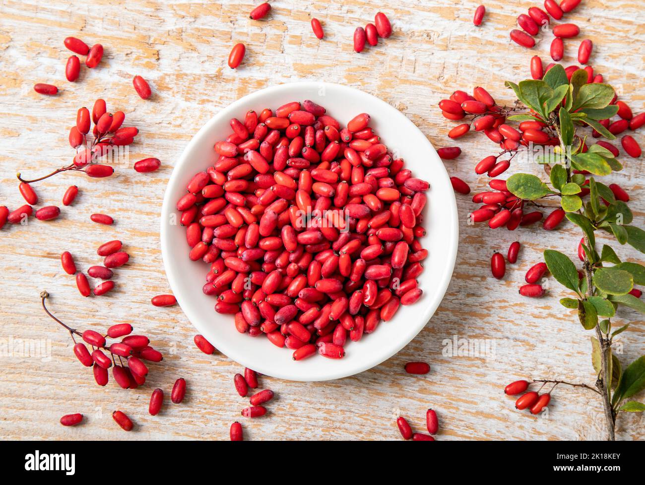Pile of Berberis vulgaris also known as common barberry, European barberry or barberry on plate in home kicthen. Edible herbal medicinal fruit. Stock Photo