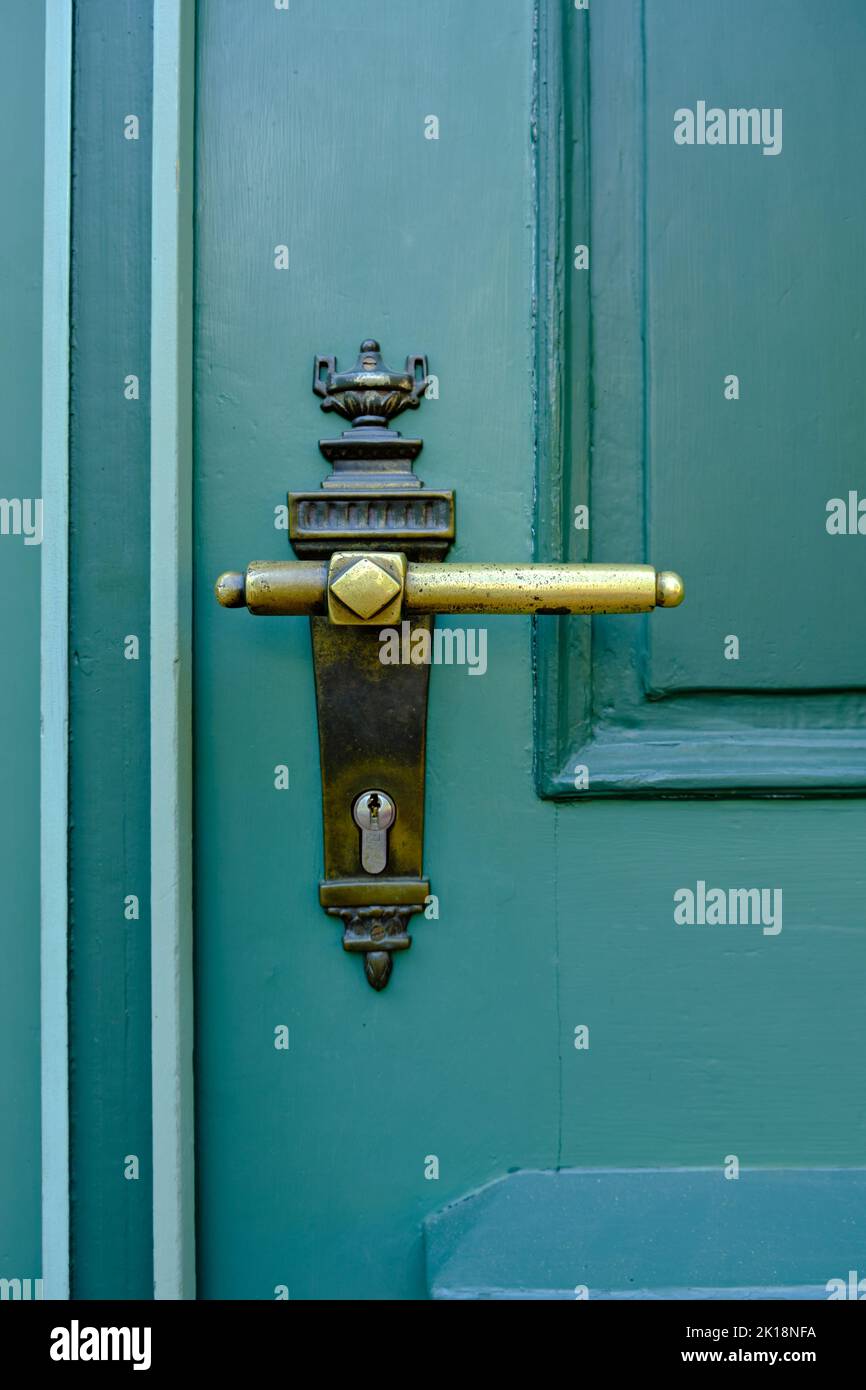 Old vintage door handle on a green door. Stock Photo