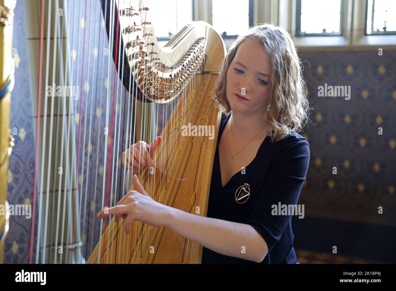 Harpist Alice Hughes performs during a reception attended by King Charles III and the Queen Consort, for local charities at Cardiff Castle in Wales. Picture date: Friday September 16, 2022. Stock Photo