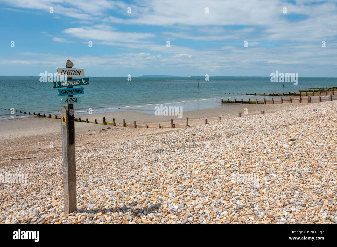 Caution Mermaid swimming area sign on beautiful deserted beach at Selsey West Sussex England Stock Photo
