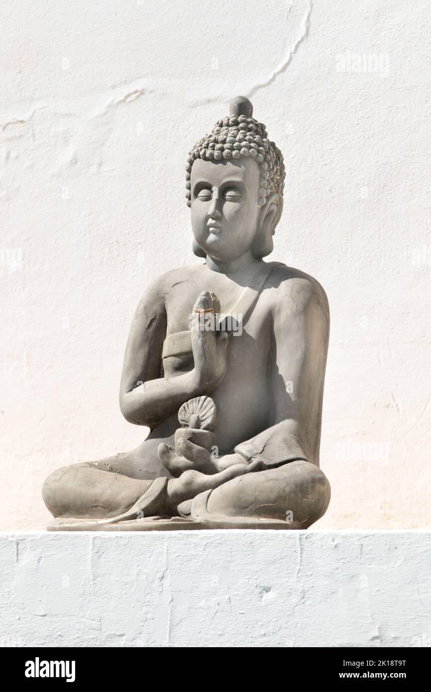 Stone statue of Buddha on a wall in Ibiza, Balearic Islands, Spain Stock Photo