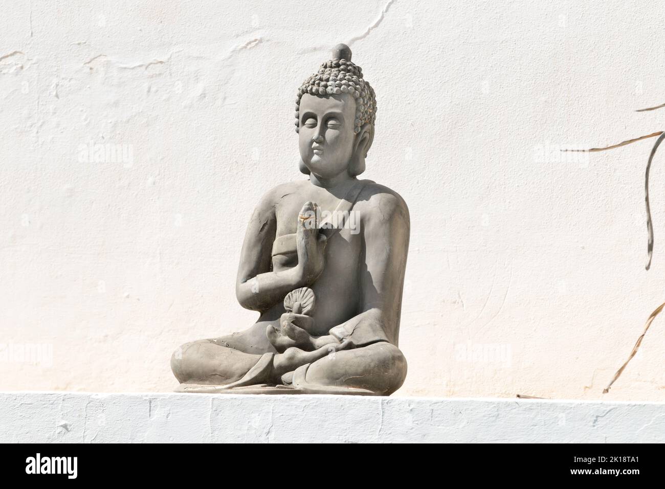 Stone statue of Buddha on a wall in Ibiza, Balearic Islands, Spain Stock Photo