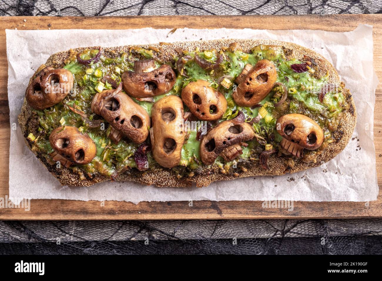 Halloween spooky pizza bread with skull-shaped mushroom. Stock Photo