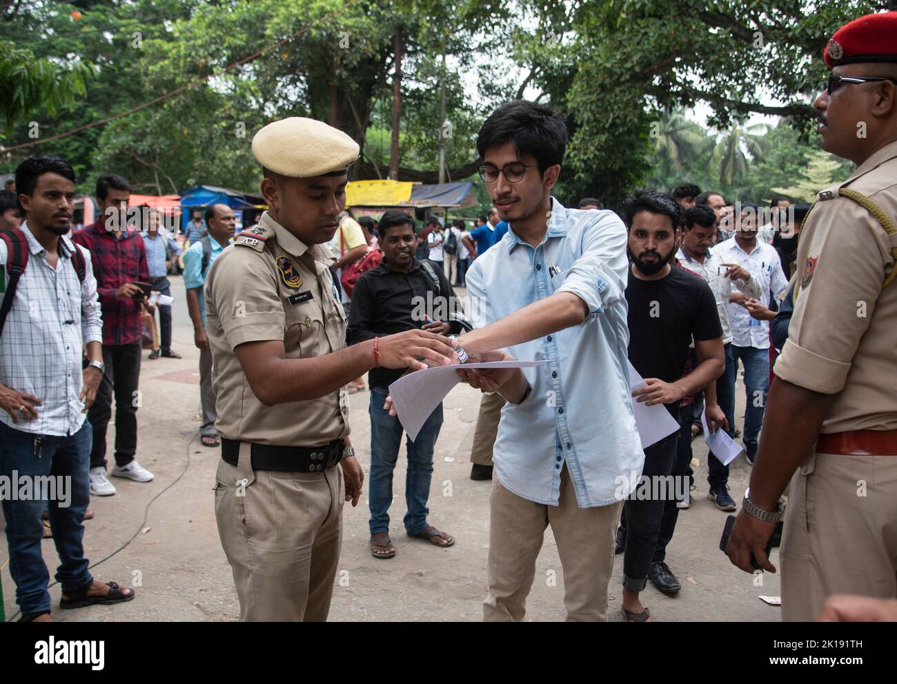 GUWAHATI, INDIA - AUGUST 28: A police person checks wrist watch of an aspirant before enter an examination hall for Recruitment of Class III and IV posts, at a examination centre on August 28, 2022 in  Guwahati, India. More than 1.4 million candidates are expected to appear for nearly 30,000 Grade-III and -IV posts in Assam. Mobile internet services across 25 districts of Assam have been suspended during exam in order to prevent possible malpractices. Stock Photo