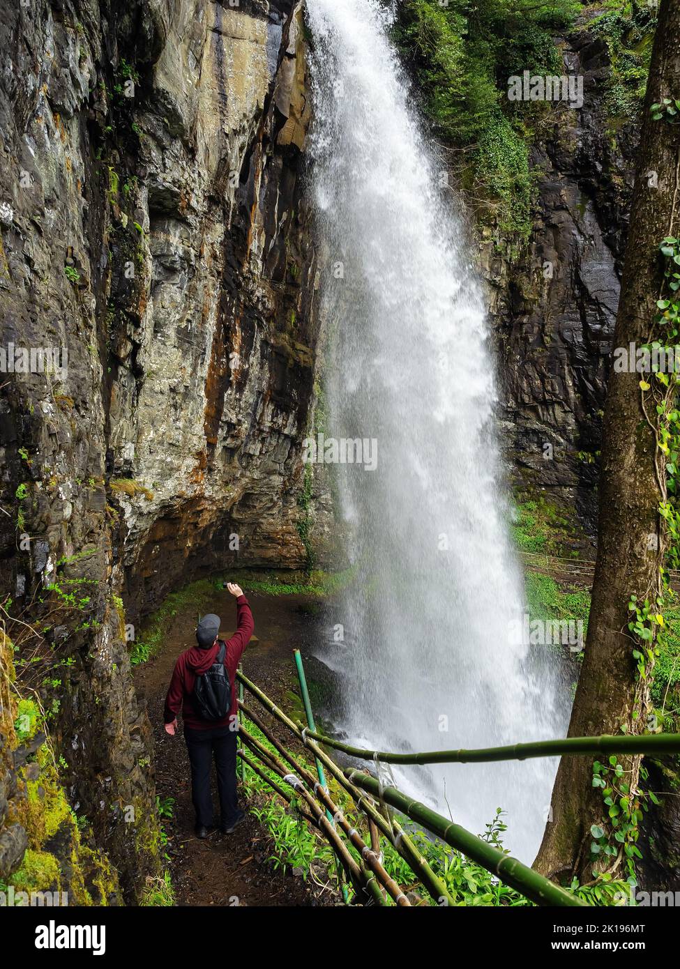 Stand under a rock looking at a waterfall Stock Photo Alamy