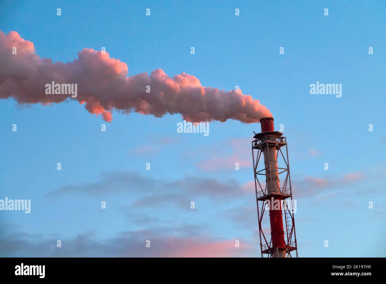 Steam comes from a metal pipe of a thermal power plant. thermal pollution and greenhouse effect of the planetary atmosphere Stock Photo