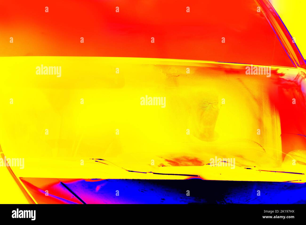 Driving a car on a sunny day. The driver is visible behind the windshield. Illustration of thermal image. Blurred unrecognizable people. Thermal impre Stock Photo