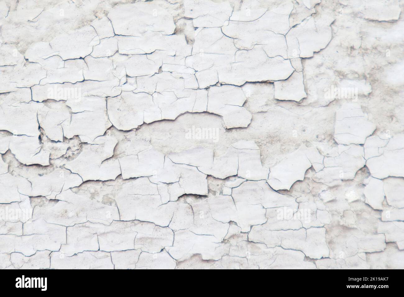 cracked white paint with chips. old paint. background Stock Photo
