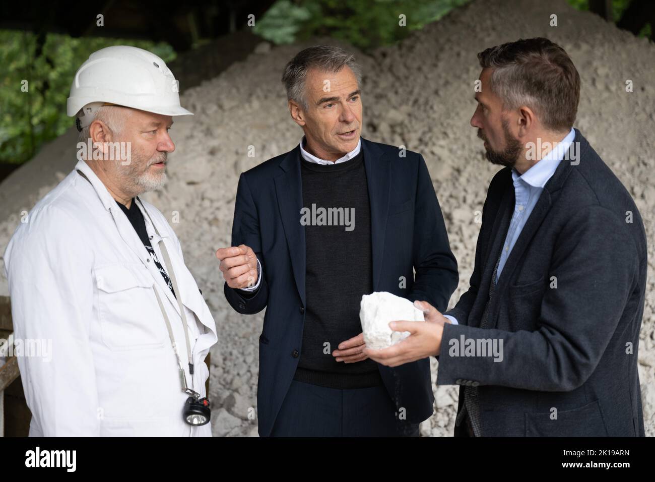 15 September 2022, Saxony, Seilitz: Martin Dulig (SPD, r), Saxony's Minister of Economic Affairs, stands next to Andreas Kawka (l), Steiger, and Tillmann Blaschke, Managing Director of the porcelain manufactory, holding a piece of kaolin as part of a 'raw materials tour' at the Seilitz white earth plant. Kaolin for the Meissen porcelain manufactory has been mined in the white earth plant without interruption since 1764. Photo: Sebastian Kahnert/dpa Stock Photo