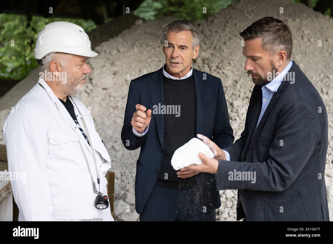 15 September 2022, Saxony, Seilitz: Martin Dulig (SPD, r), Saxony's Minister of Economic Affairs, stands next to Andreas Kawka (l), Steiger, and Tillmann Blaschke, Managing Director of the porcelain manufactory, holding a piece of kaolin as part of a 'raw materials tour' at the Seilitz white earth plant. Kaolin for the Meissen porcelain manufactory has been mined in the white earth plant without interruption since 1764. Photo: Sebastian Kahnert/dpa Stock Photo