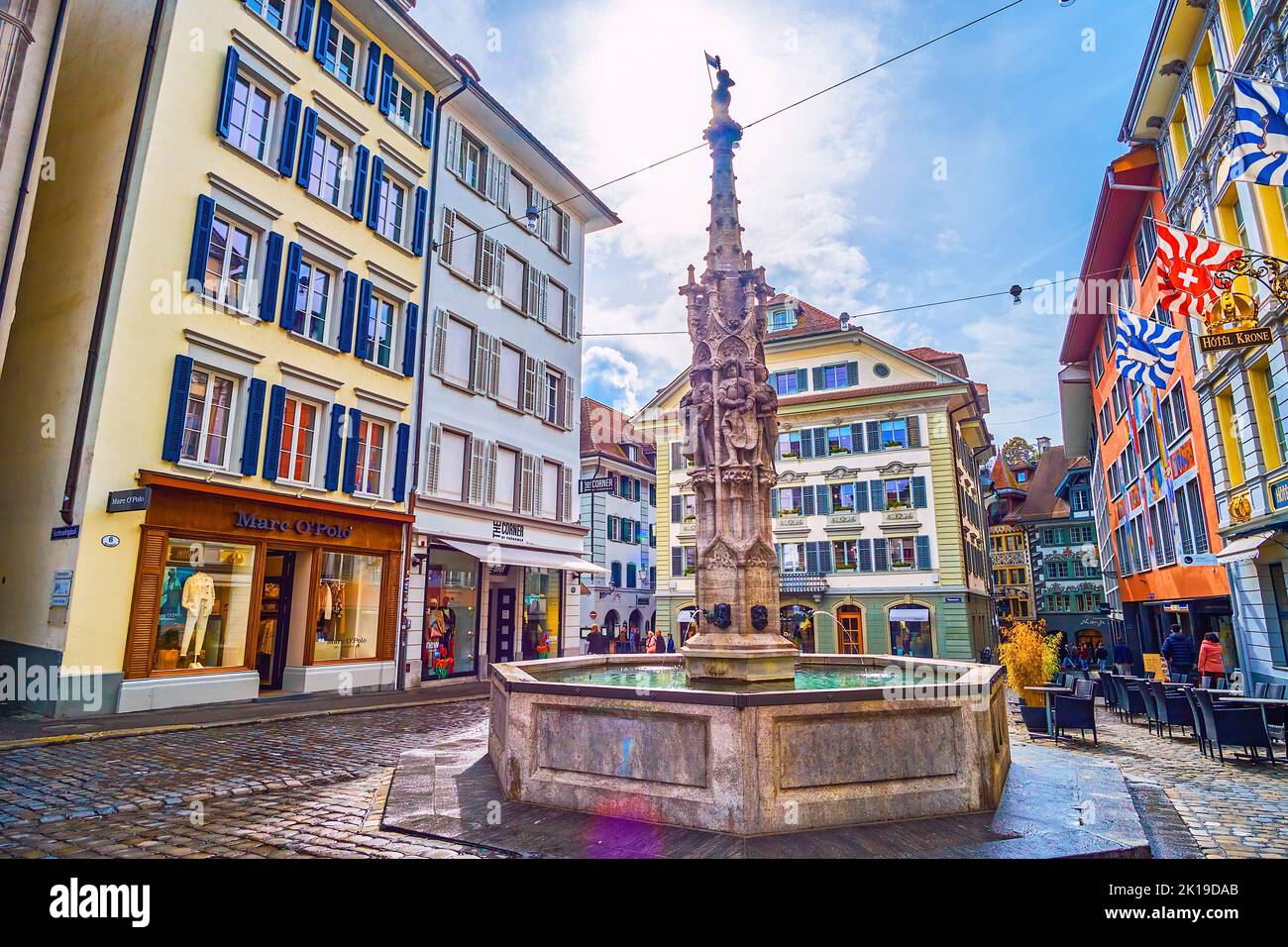 LUCERNE, SWITZERLAND - MARCH 30, 2022: The medieval limestone fountain on Weinmarkt square in surrounding of outstanding old houses, on March 30 in Lu Stock Photo