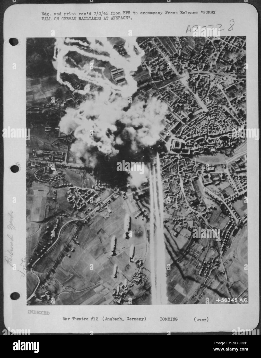 BOMBS FALL ON GERMAN RAILYARDS AT ANSBACH--Bombs from U.S. Army 8th Air Force B-17 Flying Fortresses of the Third Air Division fall on and around the vital railway marshalling yards at Ansbach, Germany, making tangled wreckage of the Stock Photo