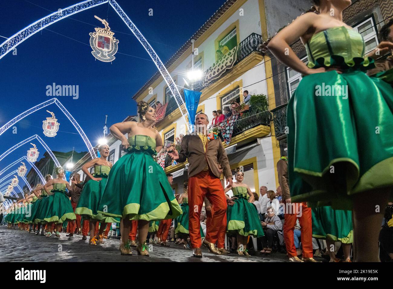 Costumed performers dance down the Rua da Se during a traditional