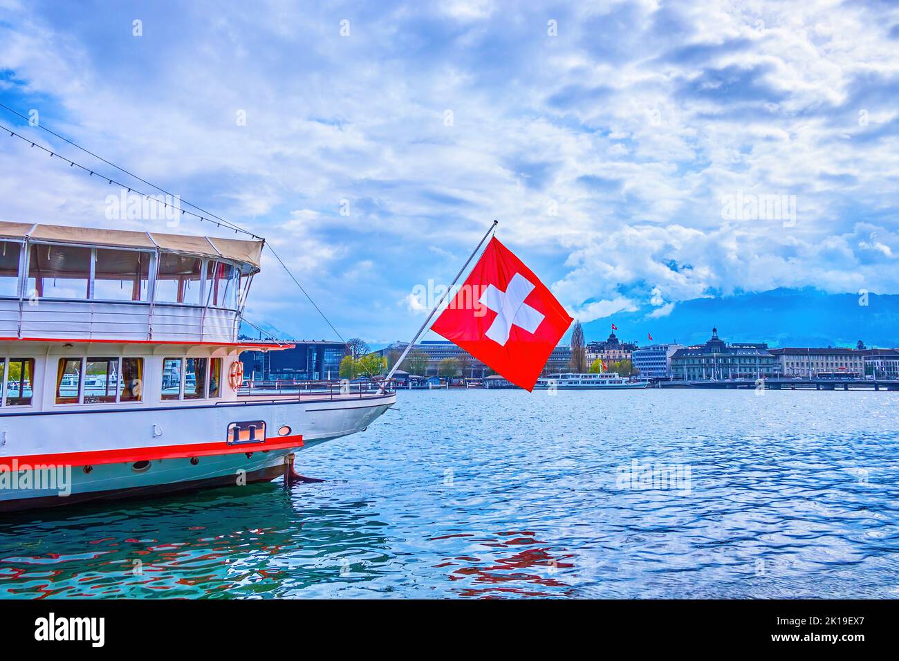 The huge Swiss flag on the boat, moored at the pier of Lucerne Lake, Lucerne, Switzerland Stock Photo
