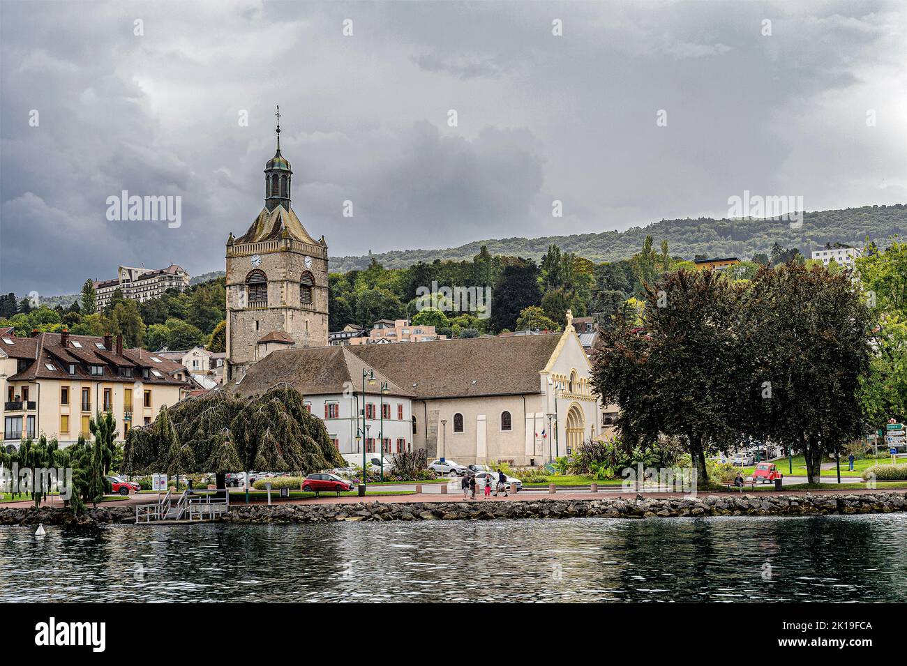 The church 'Notre-Dame-de-l'Assomption' dates from the 13th century. Seen from a boat on the lake. This elegant church has been restored several times. Stock Photo