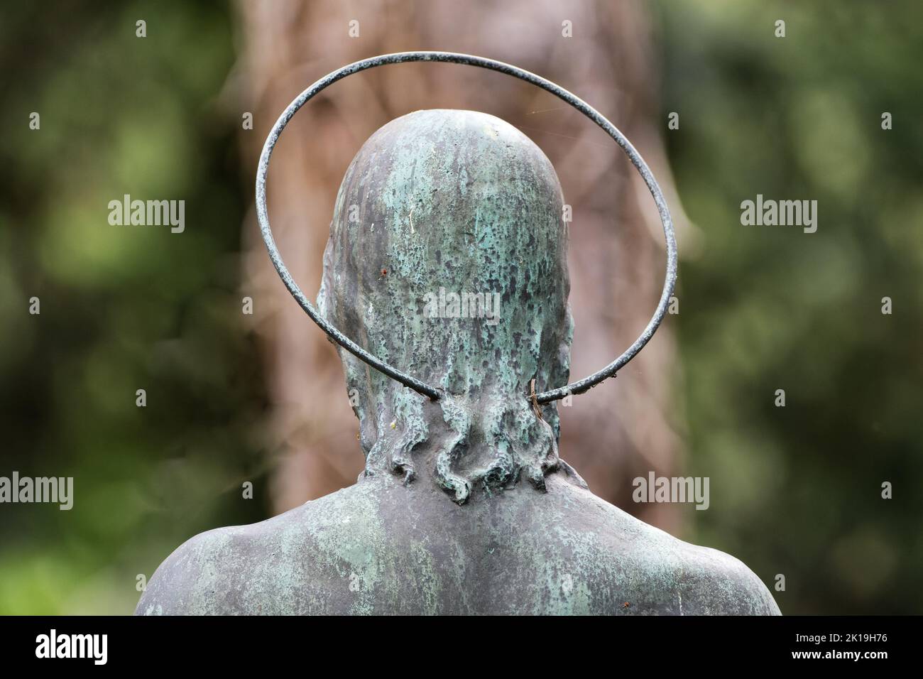 back of a jesus figure with a halo in a cemetery Stock Photo