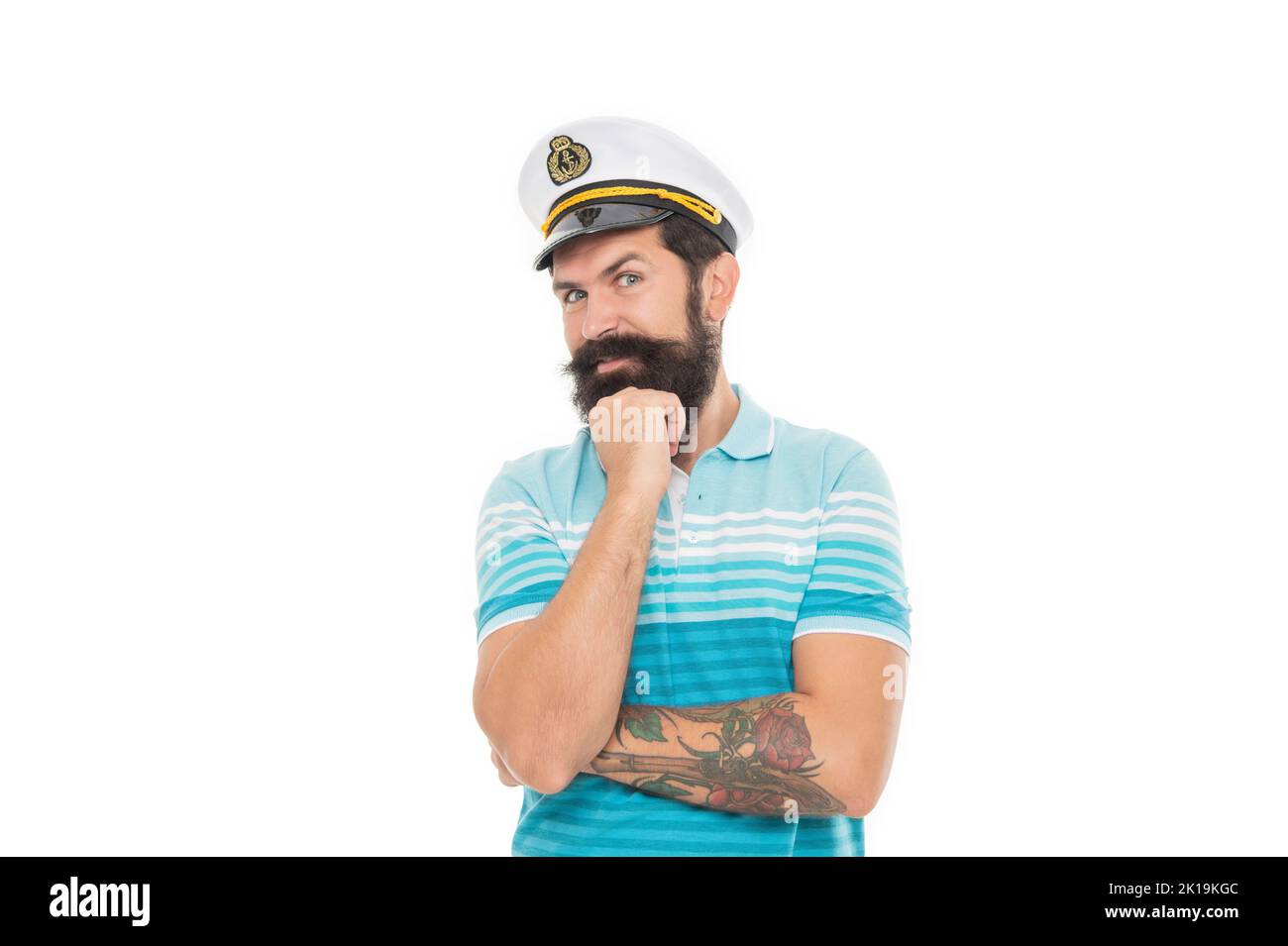 Happy captain propping chin. Bearded man wearing captain hat. Man