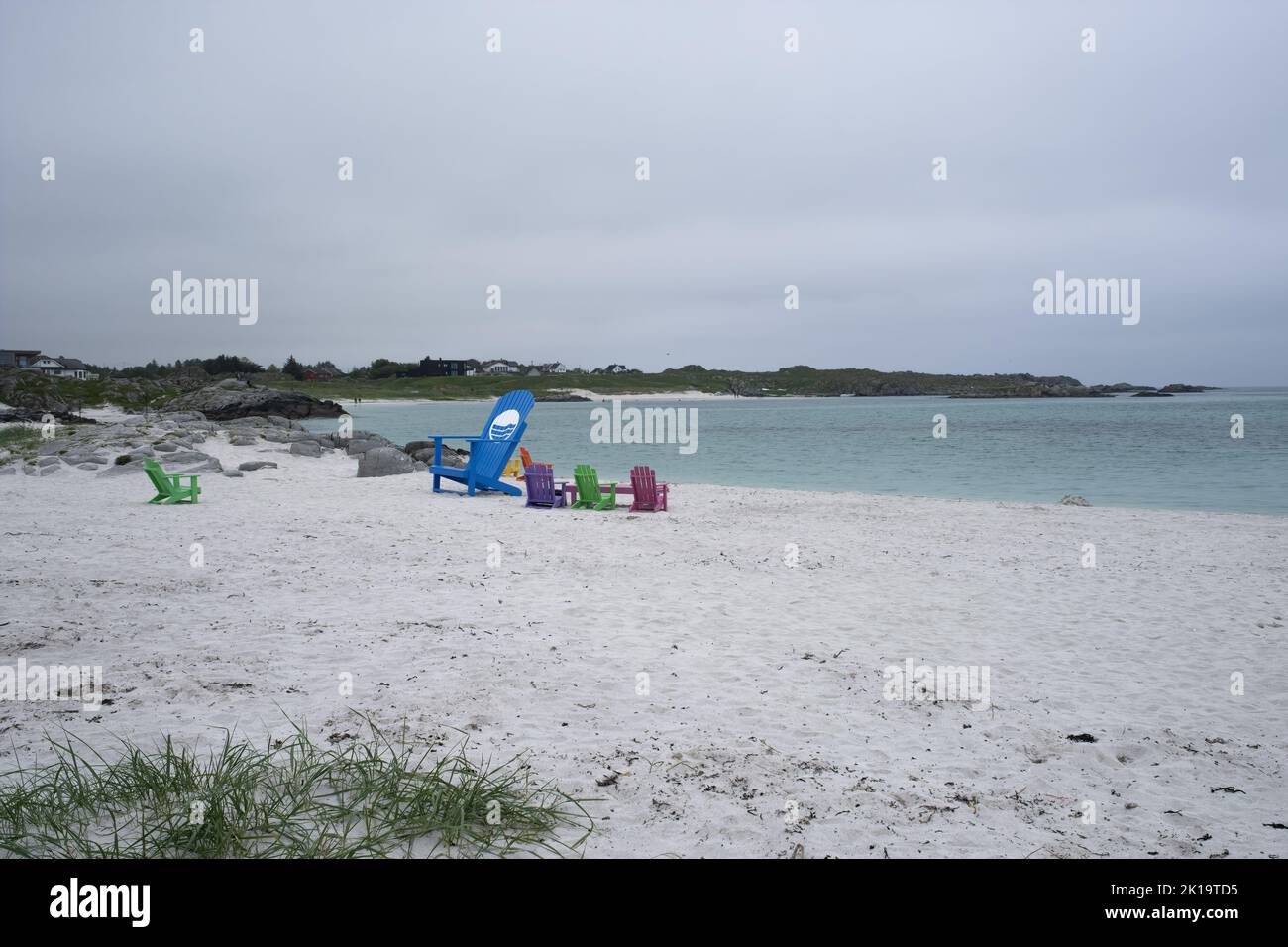 Wonderful landscapes in Norway. Colorful chairs on the beach.  Cloudy day. Selective focus Stock Photo