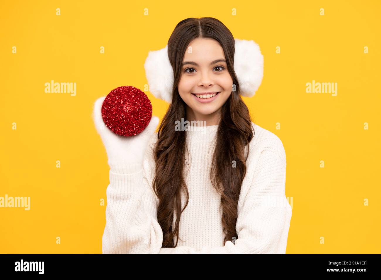Teenager child santa girl in fur sweater, christmas ball isolated on yellow background. Happy New Year, celebration holiday concept. Stock Photo