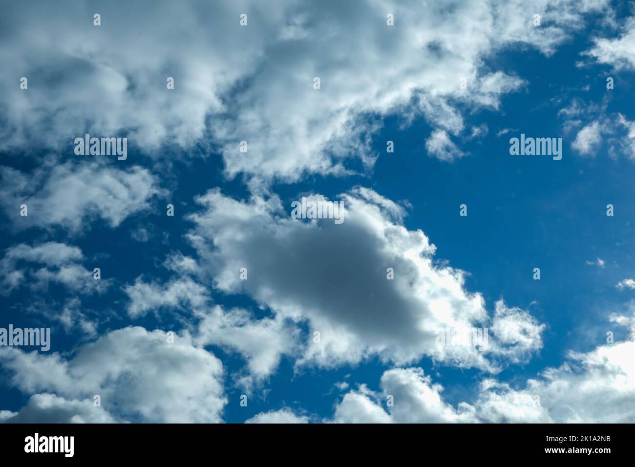 Blue sky with thunderclouds. The sun breaks through the clouds. Black clouds. Stock Photo