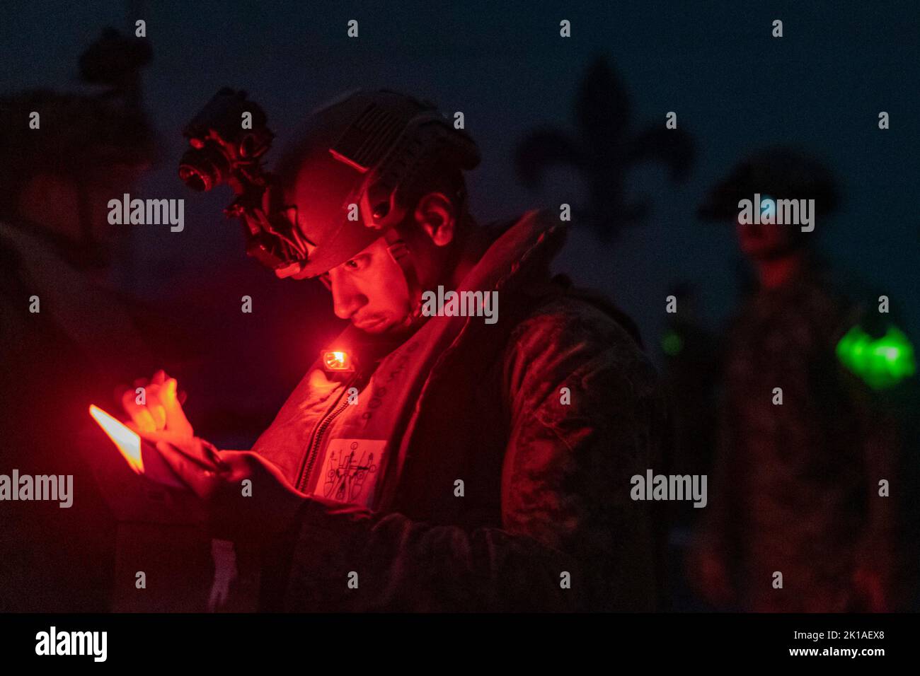A U.S. Marine with Battalion Landing Team 2/5, 31st Marine Expeditionary Unit, writes down information before a night casualty evacuation exercise aboard USS New Orleans (LPD 18) in the Sea of Japan, Sept. 11, 2022. This integrated training establishes confidence and familiarity between the Marines and Sailors for in-flight medical treatment. The 31st MEU is operating aboard ships of the Tripoli Amphibious Ready Group in the 7th fleet area of operations to enhance interoperability with allies and partners and serve as a ready response force to defend peace and stability in the Indo-Pacific Reg Stock Photo