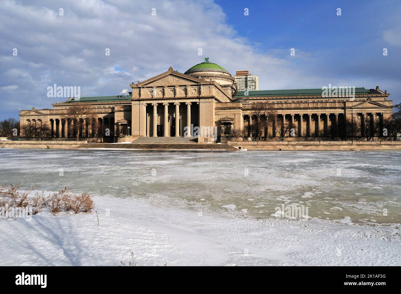 Chicago, Illinois, USA. The renowned Museum of Science & Industry pictured in winter behind a frozen lagoon in Jackson Park on the city's South Side. Stock Photo