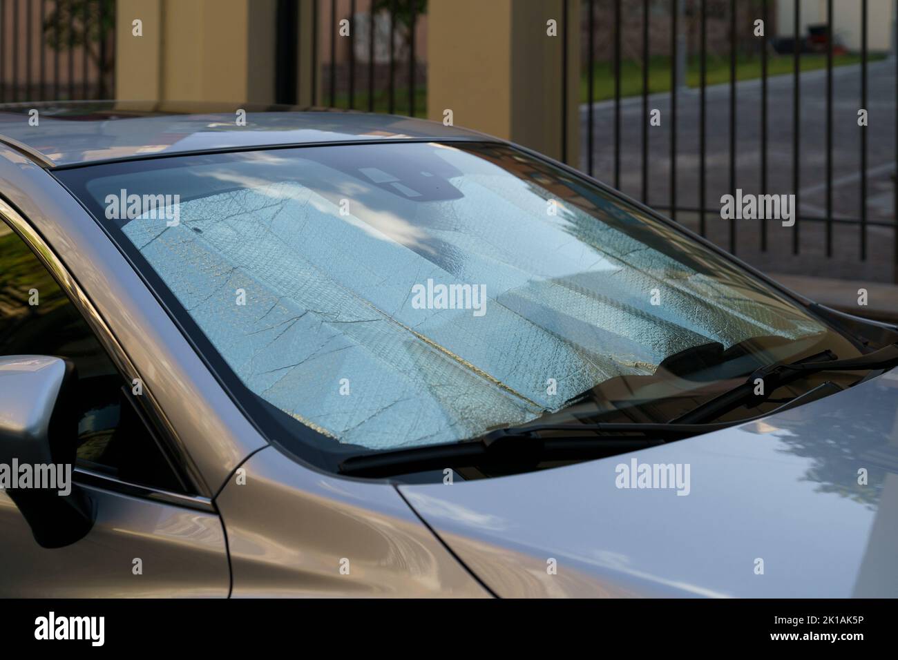 Protective reflective surface under windshield of car on hot day