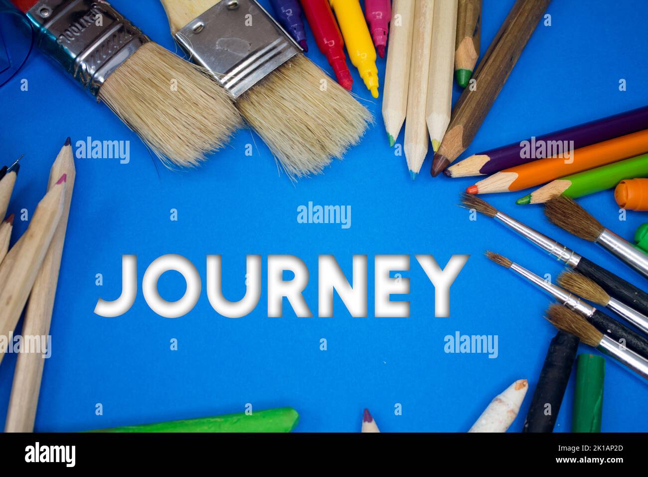 Overhead shot of school supplies with Journey text. Brushes, pencils