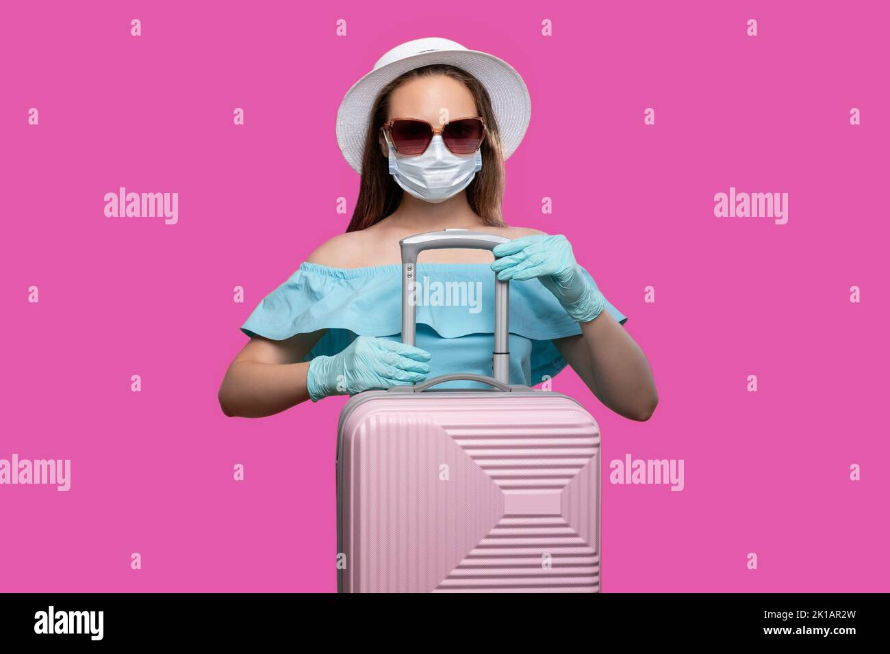Borders opened. COVID-19 prevention. Woman with suitcase isolated on lilac. Pandemic measures. Ready for traveling. Summer vacation Stock Photo