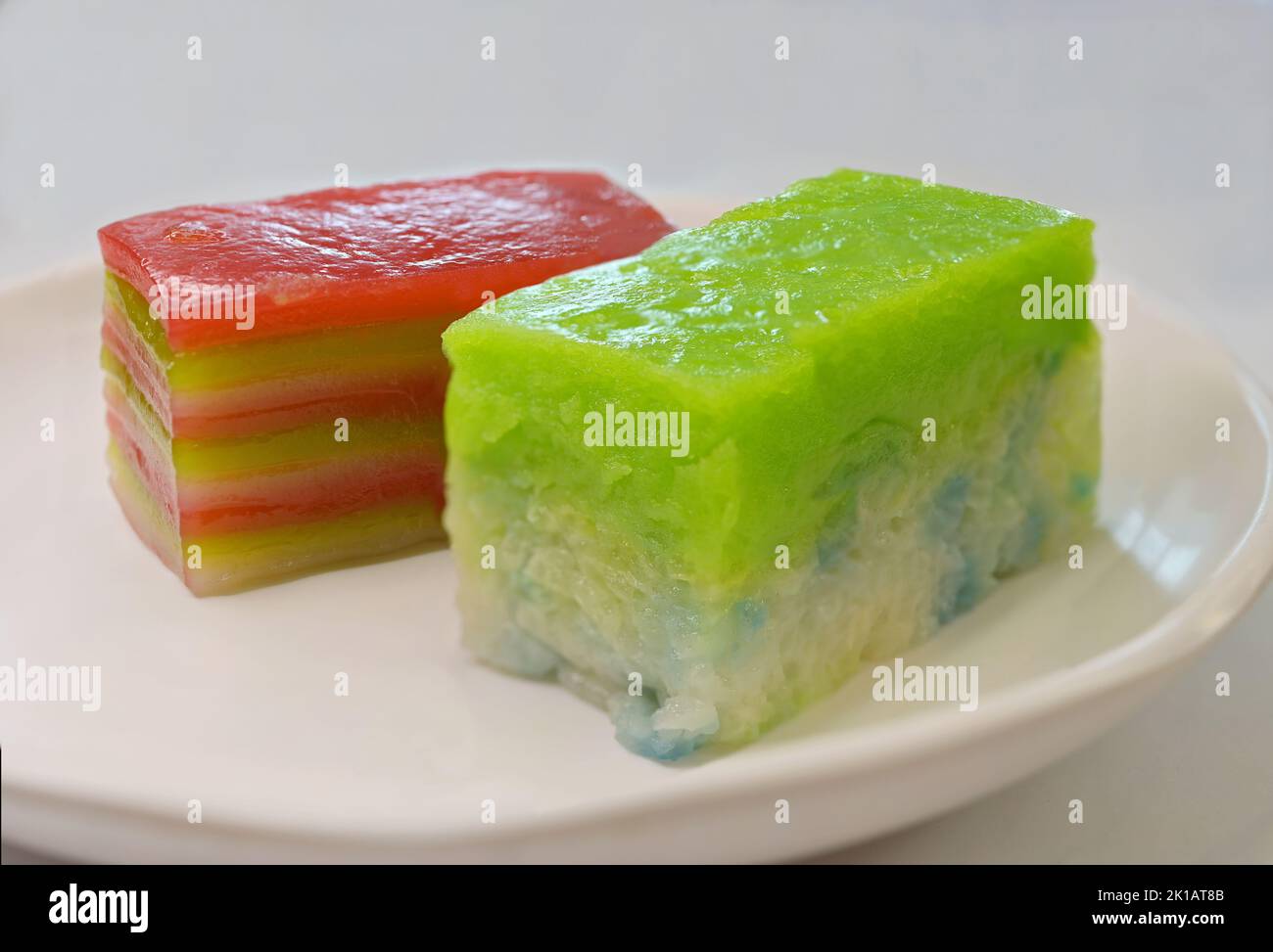 Kueh Seri Muka and Kueh Lapis, colorful traditional Peranakan Straits Chinese or Nyonya snacks, on white dessert plate Stock Photo