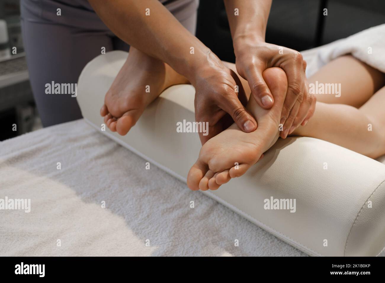 Child Foot massage treatment by professional massage therapist in spa resort. Wellness, stress relief and healthcare concept Stock Photo