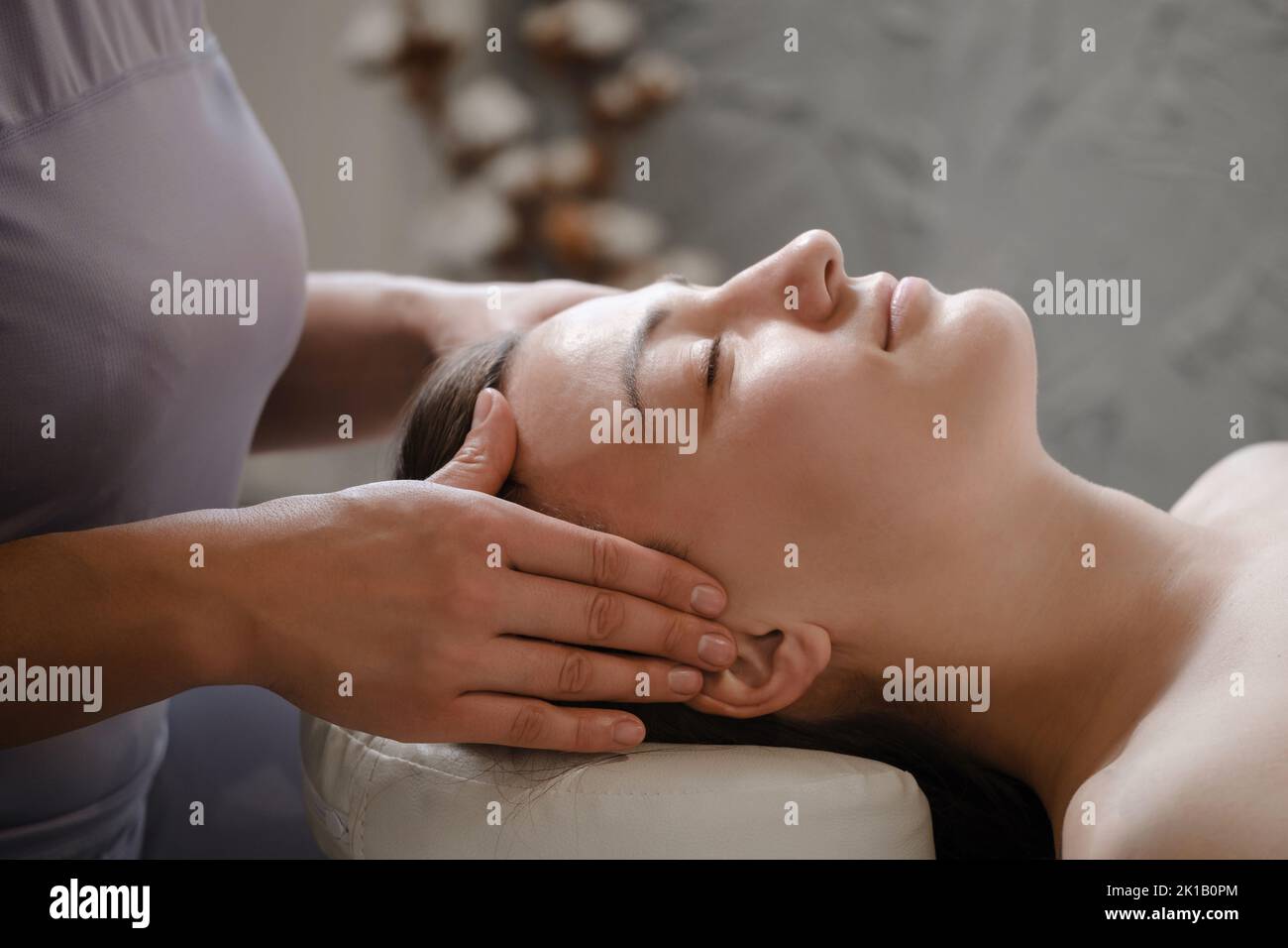 face massage with oil in traditional style made by professional beauty therapist women. anti-age massage Stock Photo