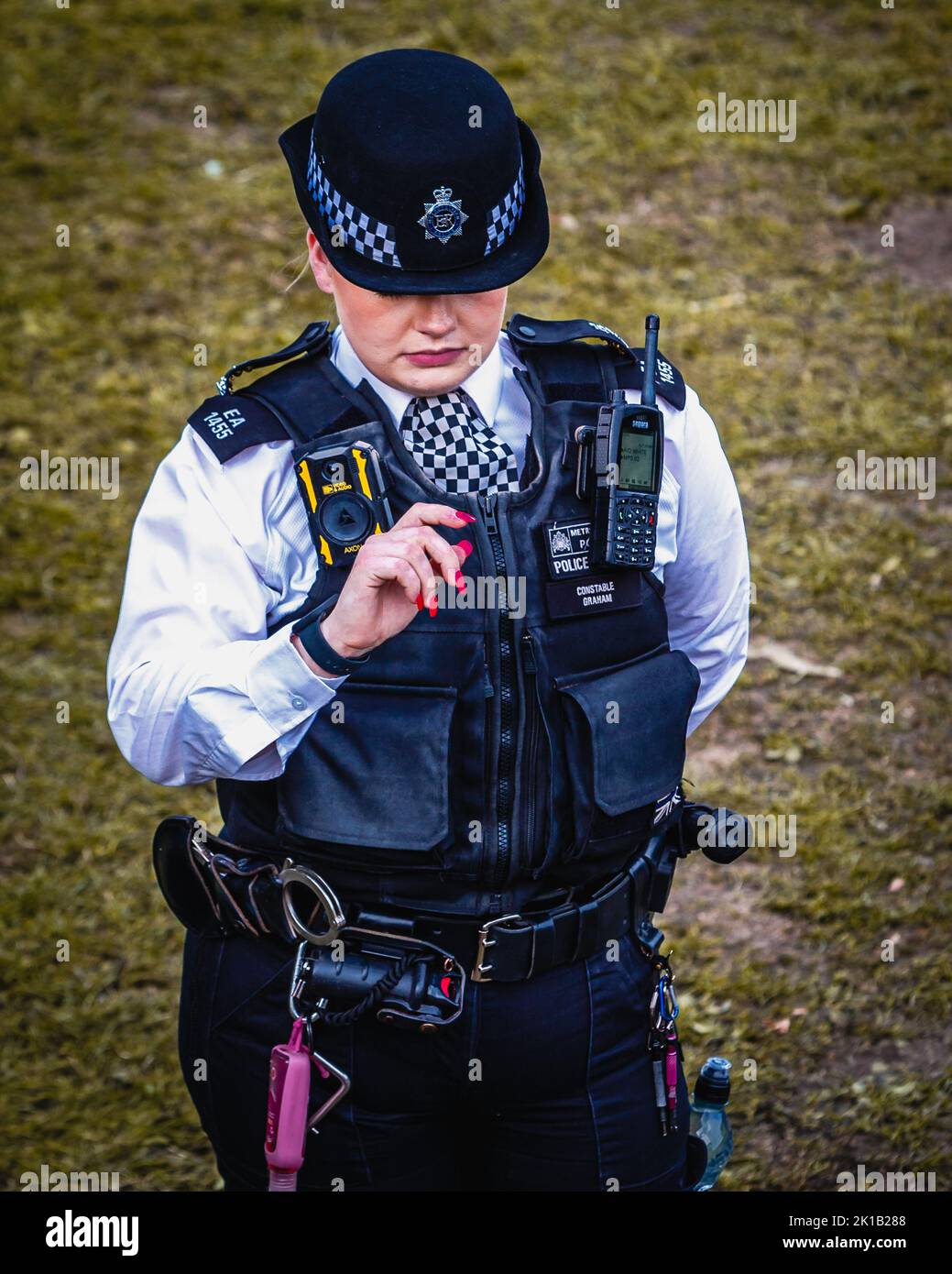 An emotional police officer wipes away tears as she takes time to read some of the messages with the flowers left as tribute to the late Queen. Stock Photo